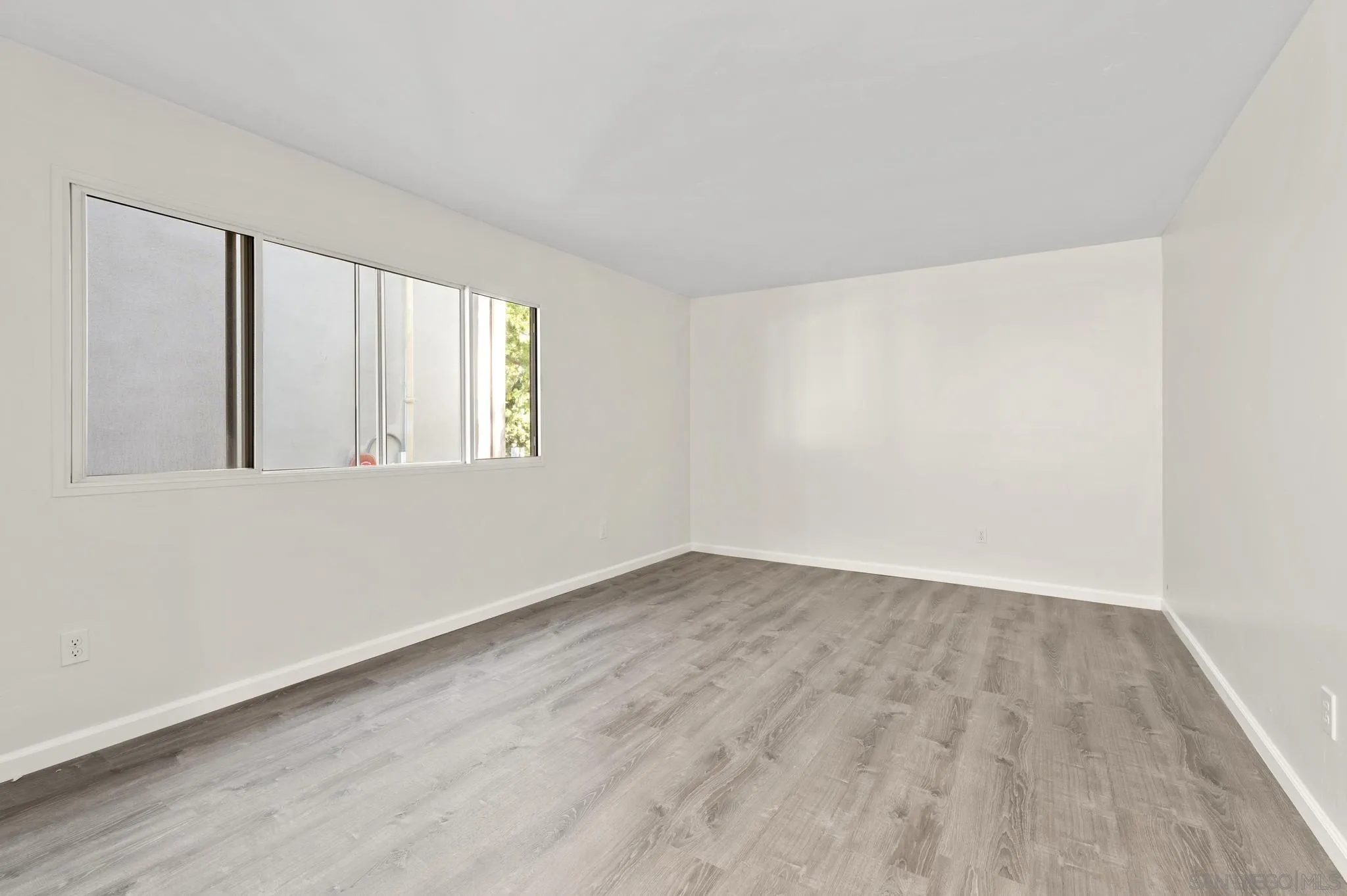 140 Walnut Avenue, Unit 2A San Diego, CA 92103 - Photo 9 of 22 an empty room with wooden floor and windows