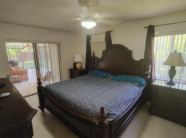 a bedroom with a bed and a flat tv screen on dresser