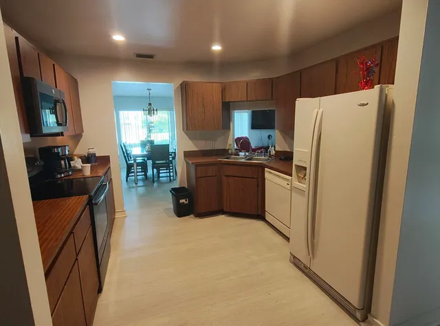 a kitchen with stainless steel appliances granite countertop a refrigerator stove and sink
