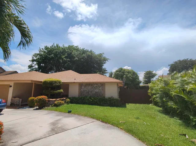 a view of a house with a yard and sitting area
