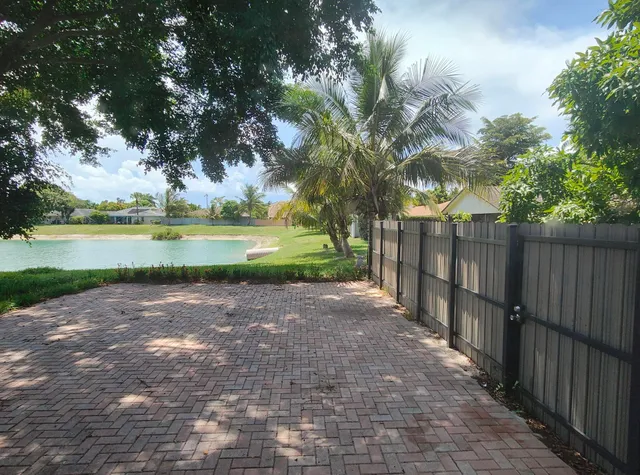 a big yard with wooden fence and trees