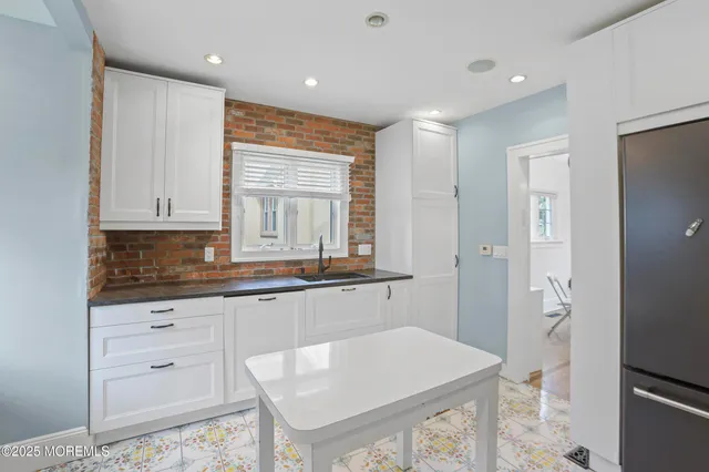 a kitchen with granite countertop white cabinets and white appliances