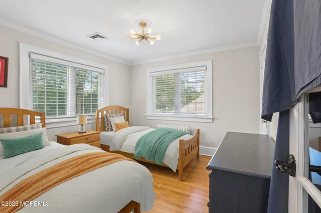 a bedroom with two beds and a large window