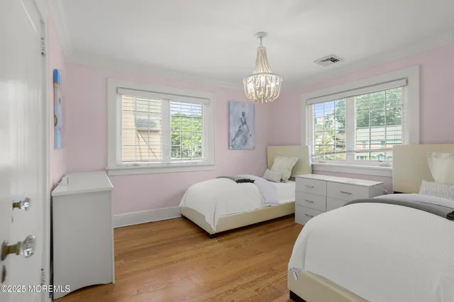 a spacious bedroom with two beds and a window