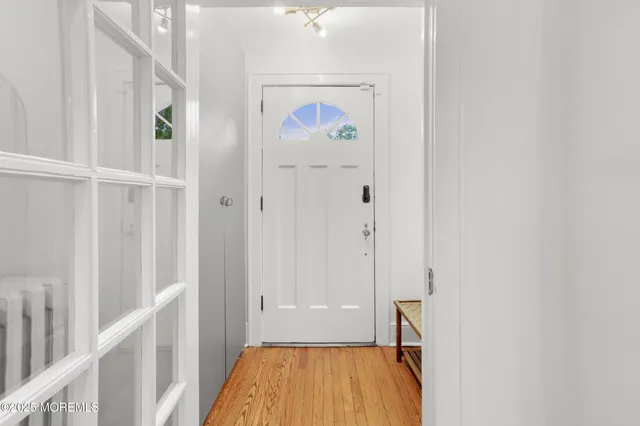 a view of a hallway with wooden floor and entryway