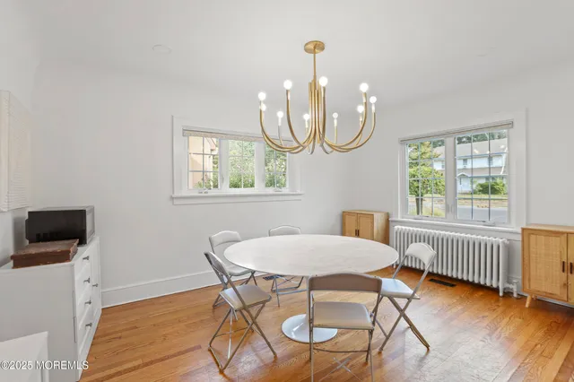 a view of a dining room with furniture a chandelier and wooden floor