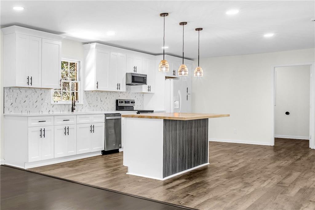 2401 Winshire Drive Decatur, GA 30035 - Photo 26 of 35 a kitchen with kitchen island sink stove and white cabinets