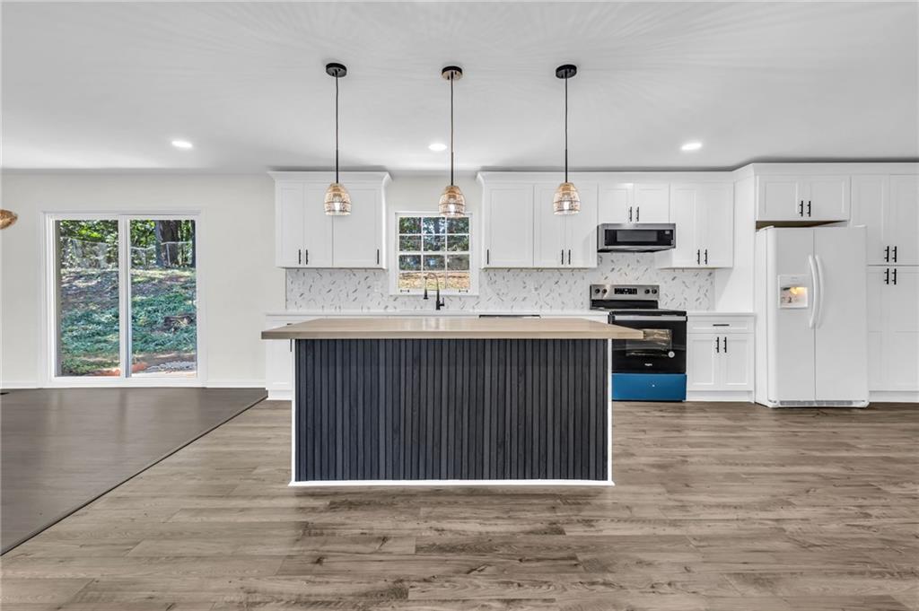 2401 Winshire Drive Decatur, GA 30035 - Photo 27 of 35 a kitchen with kitchen island a stove a sink and a window