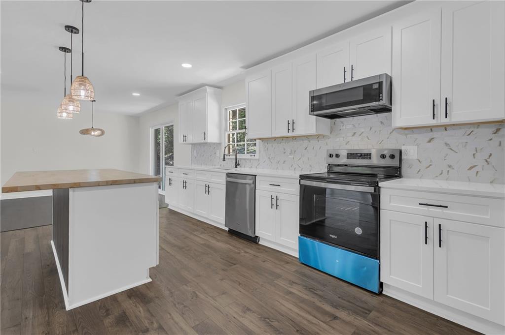 2401 Winshire Drive Decatur, GA 30035 - Photo 31 of 35 a kitchen with stainless steel appliances a sink a stove top oven a counter space and cabinets