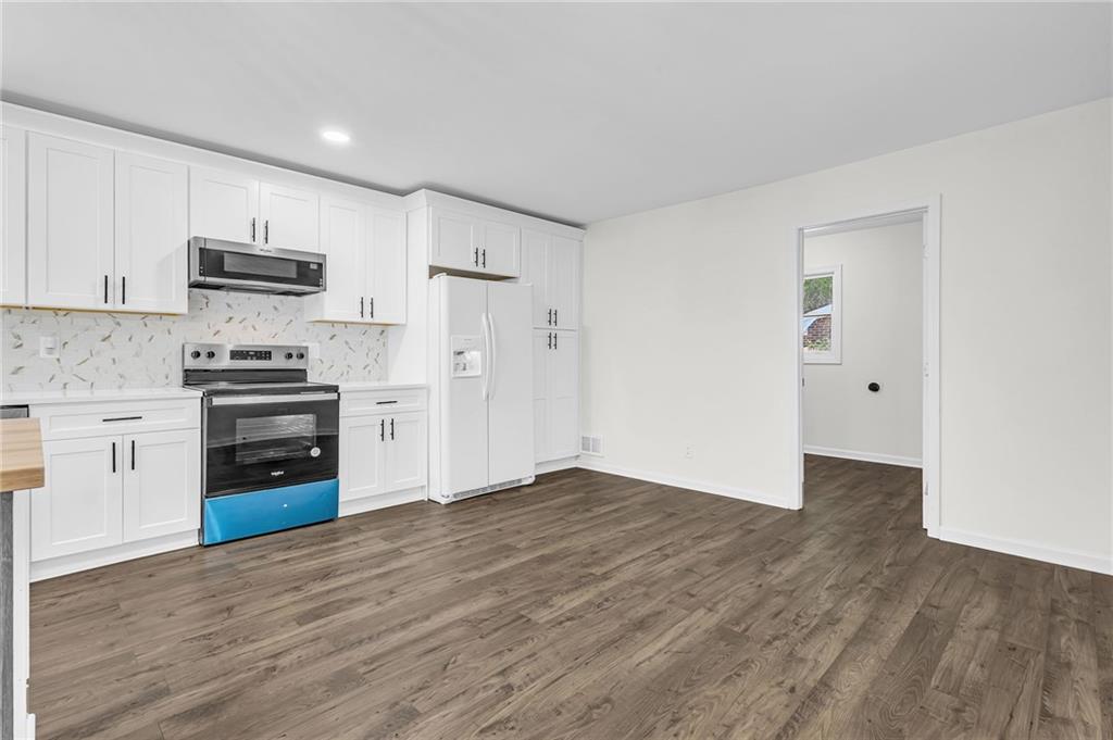 2401 Winshire Drive Decatur, GA 30035 - Photo 32 of 35 a kitchen with granite countertop a refrigerator and a stove top oven