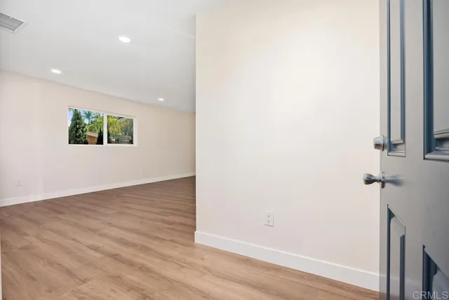 an empty room with wooden floor and a window
