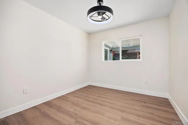 a view of a room with wooden floor and ceiling fan