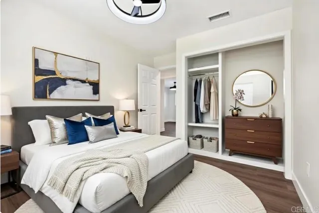 a bedroom with a bed and a mirror on the dresser