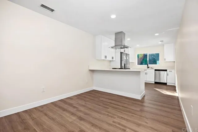 a kitchen with a sink cabinets and wooden floor