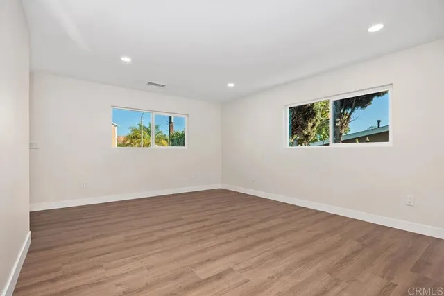an empty room with wooden floor and painting on the wall