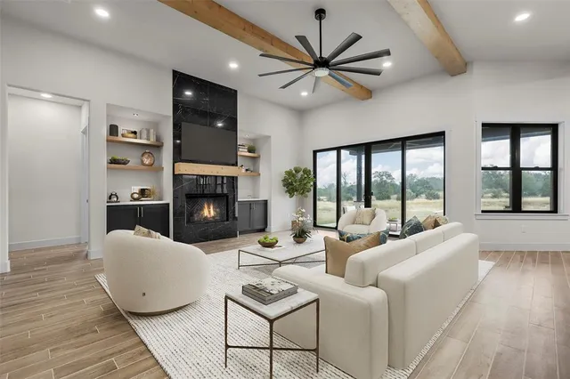 a living room with furniture a large window and a fireplace