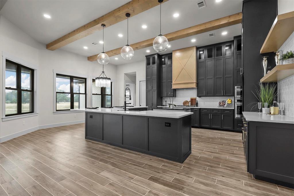 4018 Ken Road Tolar, TX 76476 - Photo 22 of 40 a large kitchen with a large counter top a sink stainless steel appliances and cabinets