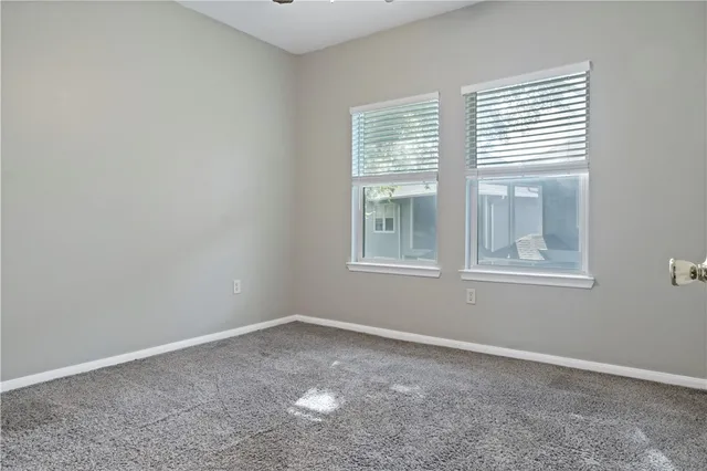 a view of an empty room with closet and a bathroom