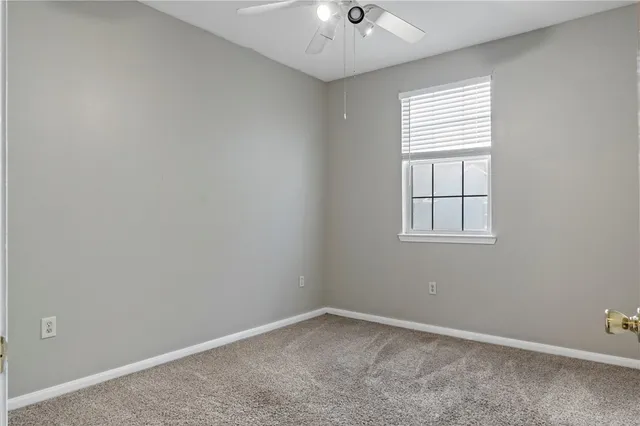 a view of a hallway with wooden floor and a bathroom
