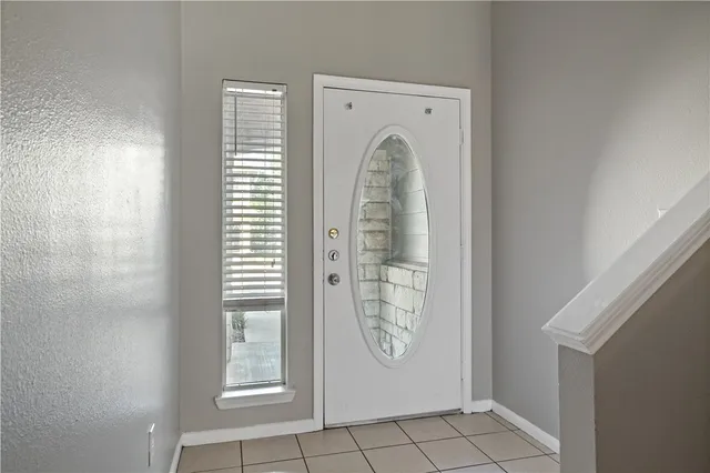 a view of an empty room with chandelier fan and wooden floor