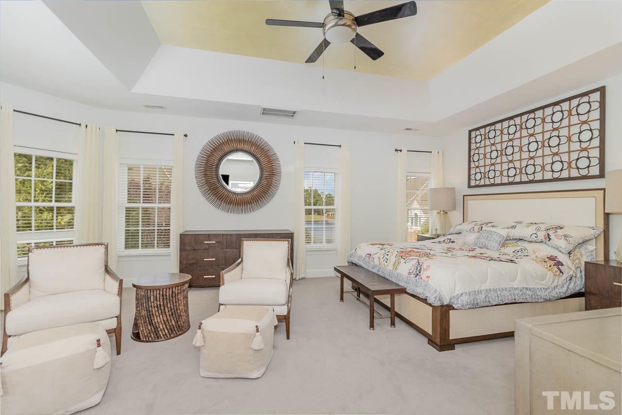 12507 Megan Hill Court Raleigh, NC 27614 - Photo 18 of 39 a spacious bedroom with a bed a couch and a window