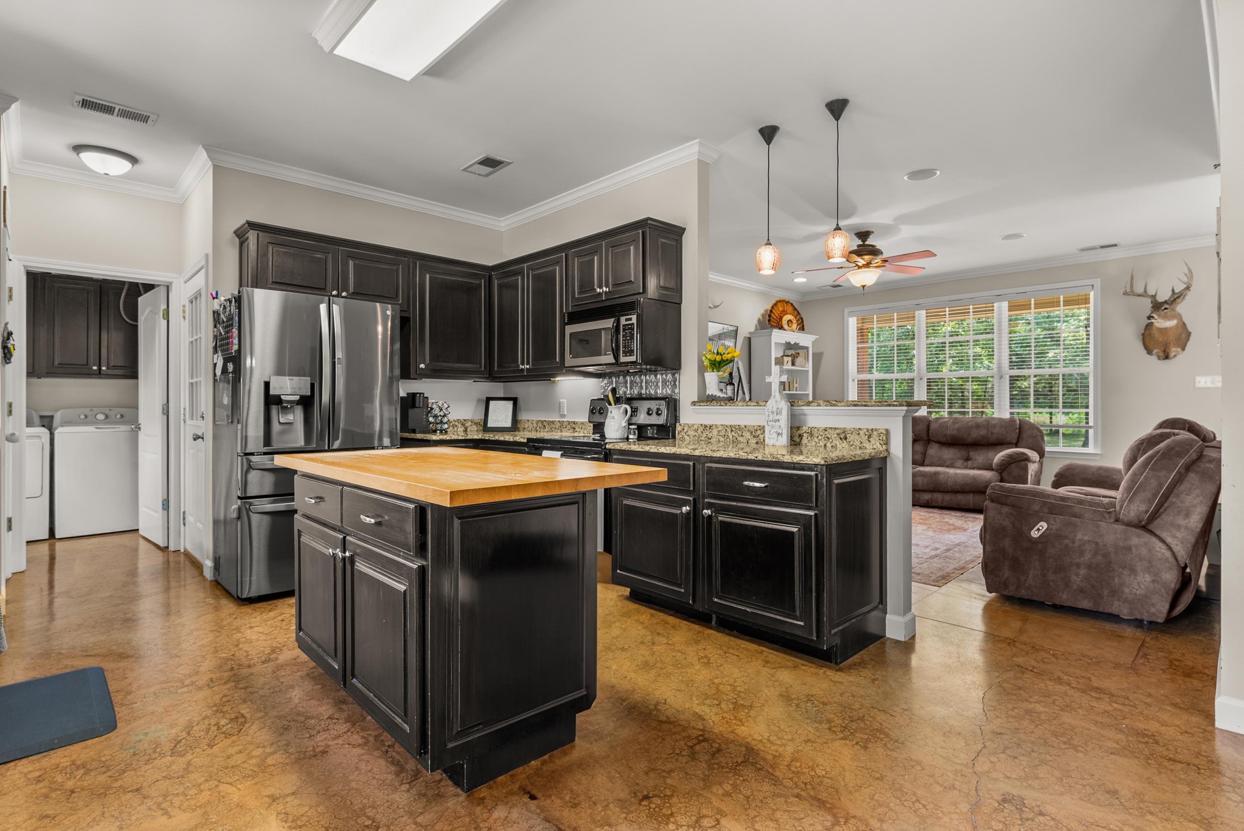 6415 Lagrange Road Somerville, TN 38068 - Photo 19 of 32 Kitchen featuring wooden counters, appliances with stainless steel finishes, dark cabinets, washer and dryer, and ornamental molding