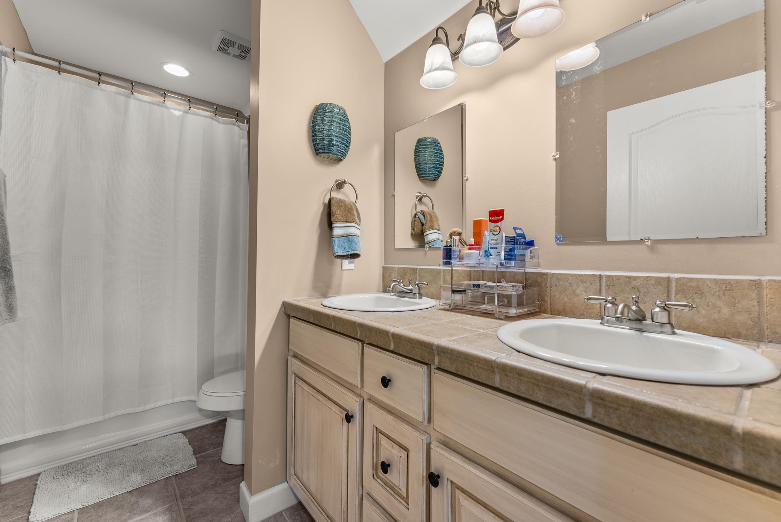 6415 Lagrange Road Somerville, TN 38068 - Photo 30 of 32 Bathroom featuring double vanity, toilet, tile patterned floors, and shower / tub combo with curtain