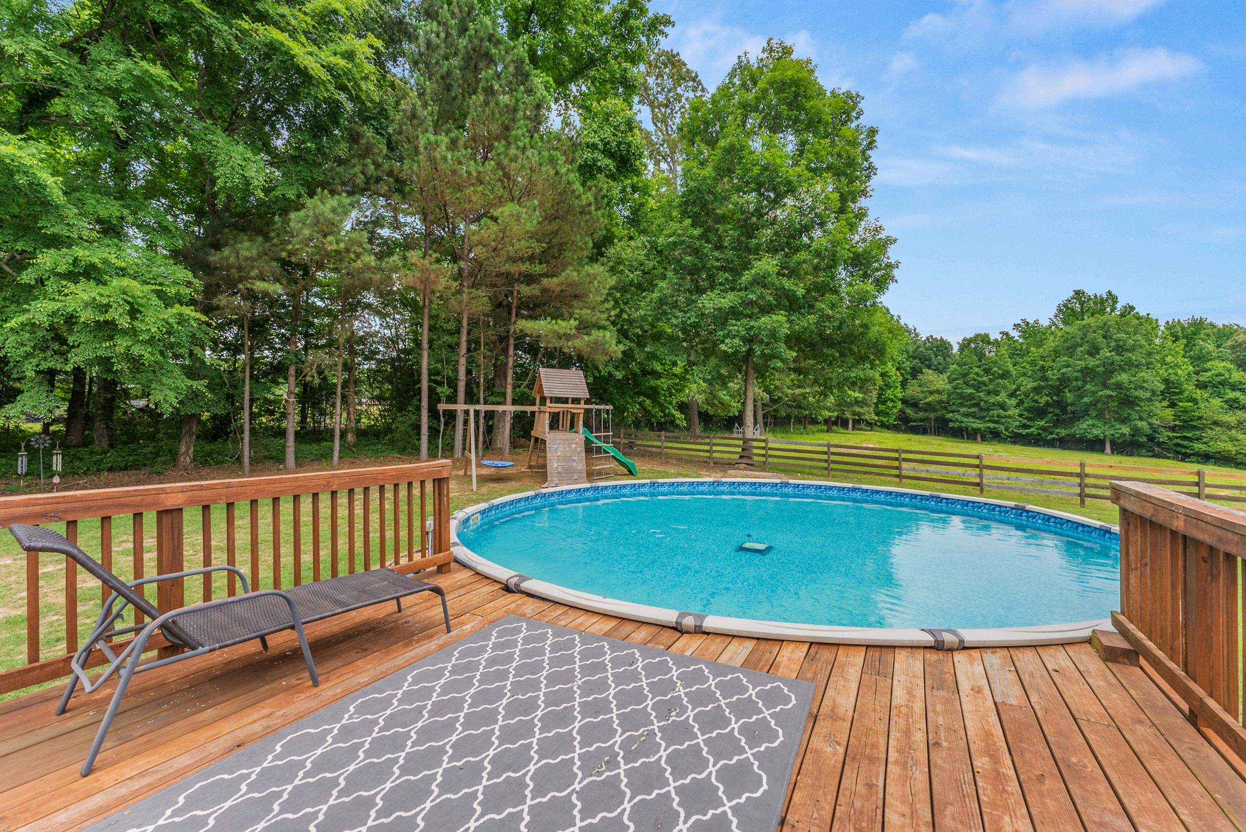 6415 Lagrange Road Somerville, TN 38068 - Photo 5 of 32 Outdoor pool with a playground, a deck, and view of wooded area