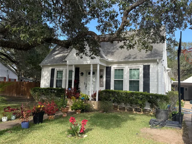 a front view of a house with a yard and potted plants
