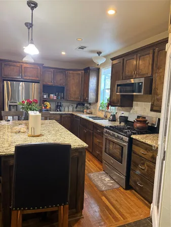 a kitchen with stainless steel appliances granite countertop a sink stove and refrigerator