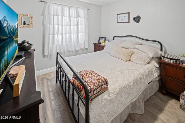 a bedroom with a bed a flat screen tv and a window