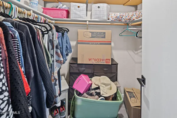 a view of walk in closet with clothes and shoes