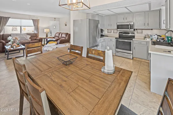 a kitchen with stainless steel appliances wooden floor dining table and chairs