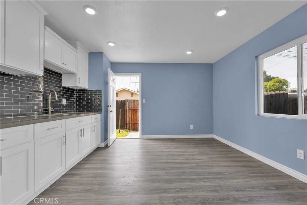 34945 Ave B Yucaipa, CA 92399 - Photo 40 of 69 a kitchen with stainless steel appliances granite countertop a refrigerator a sink dishwasher and white cabinets with wooden floor