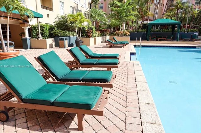 a view of a swimming pool with lounge chairs in patio