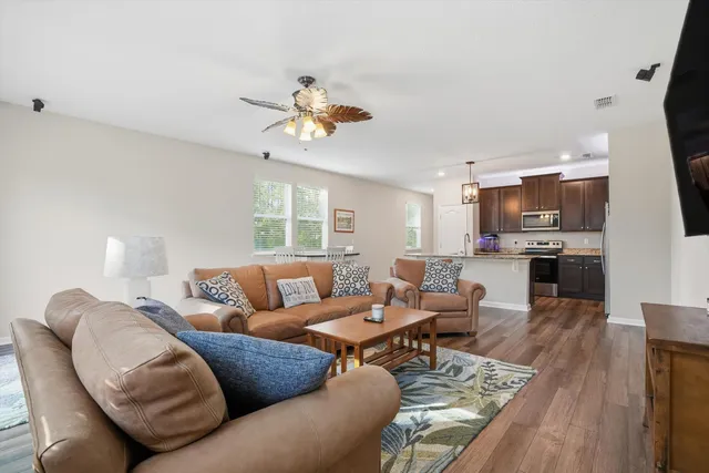 a kitchen with stainless steel appliances granite countertop a refrigerator a sink dishwasher a stove with wooden floors