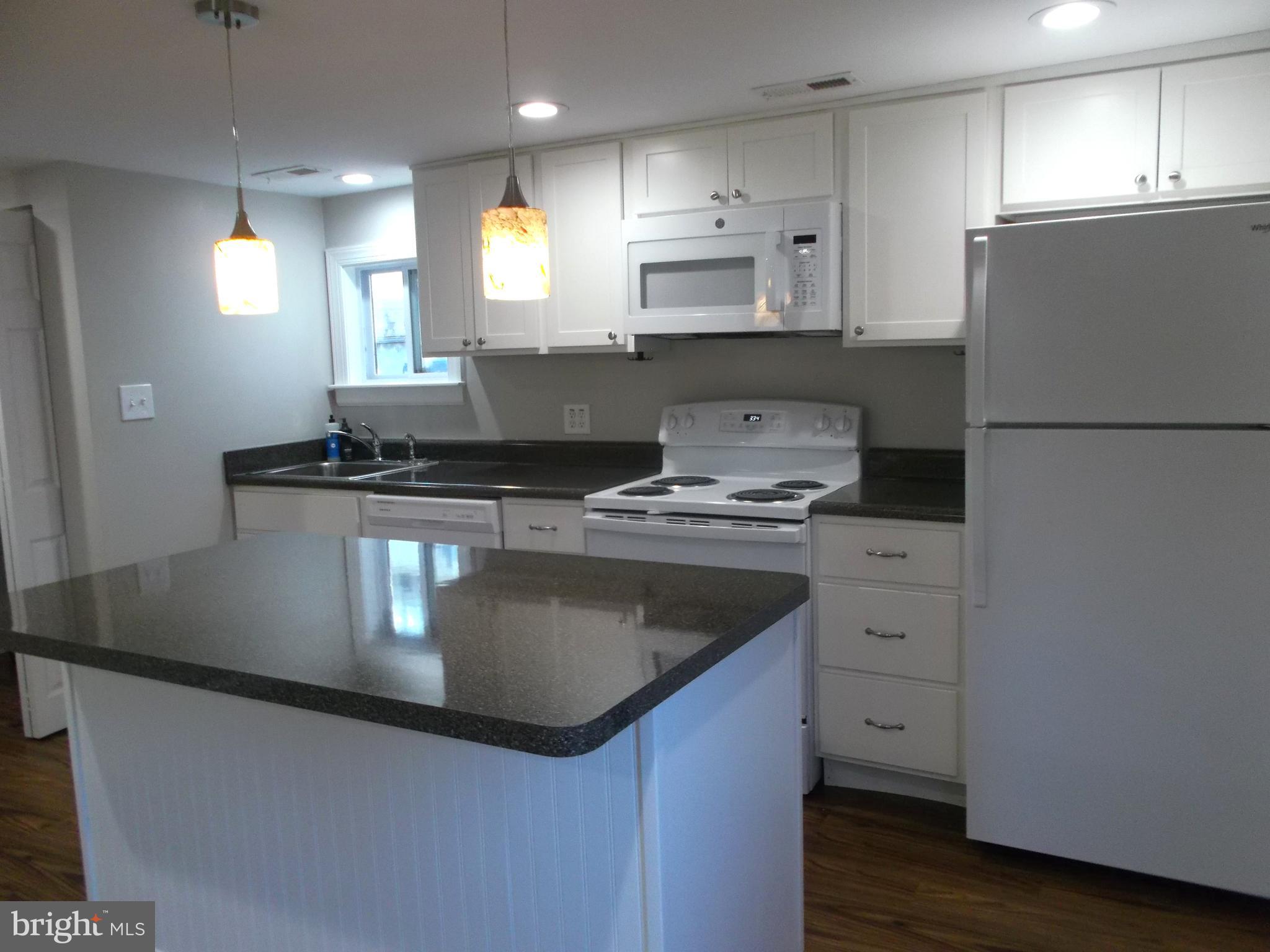 278 Ridge Road Browns Mills, NJ 08015 - Photo 5 of 22 a kitchen with kitchen island granite countertop a sink a stove a refrigerator and white cabinets