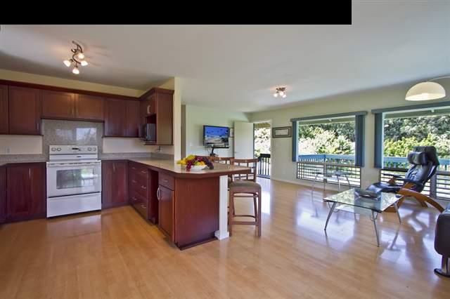 40 Kapuai Road Haiku, HI 96708 - Photo 4 of 29 a kitchen with stainless steel appliances granite countertop a stove top oven a dining table and chairs with wooden floor
