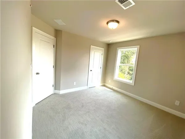 an empty room with windows and closet