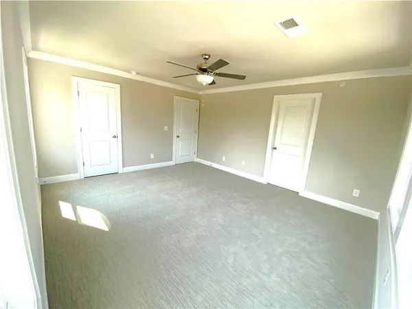 an empty room with a ceiling fan and a window