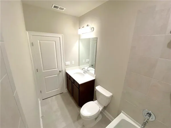 a bathroom with a sink vanity mirror and toilet