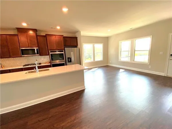 an open kitchen with wooden floor and a large window