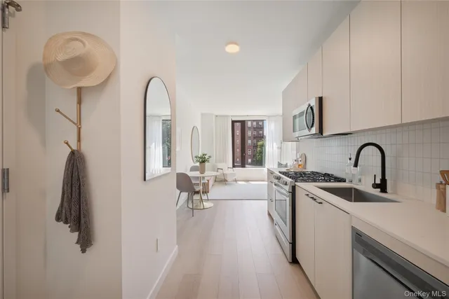 a view of living room with stainless steel appliances granite countertop furniture and a kitchen view