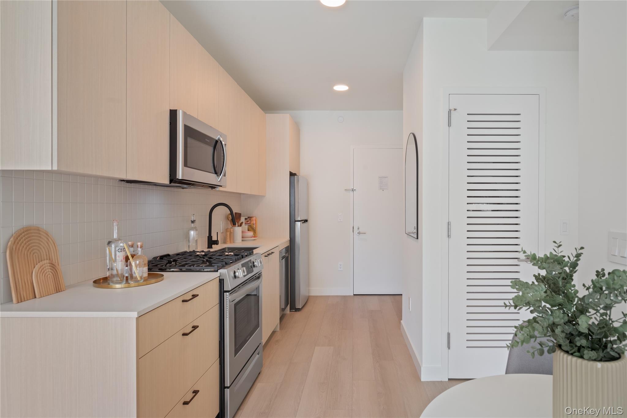 103 88th Avenue Queens, NY 11432 - Photo 7 of 29 a kitchen with stainless steel appliances granite countertop a sink stove and cabinets
