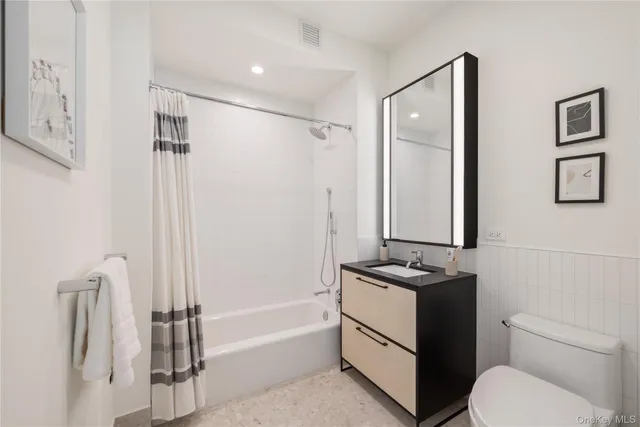 a bathroom with a granite countertop sink toilet and shower