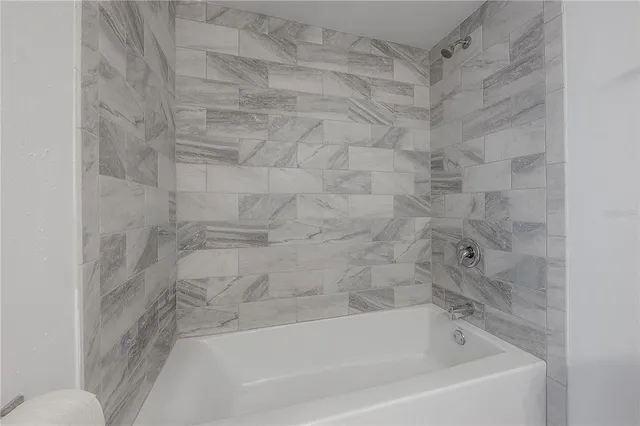 a bathroom with a granite countertop sink a mirror and shower