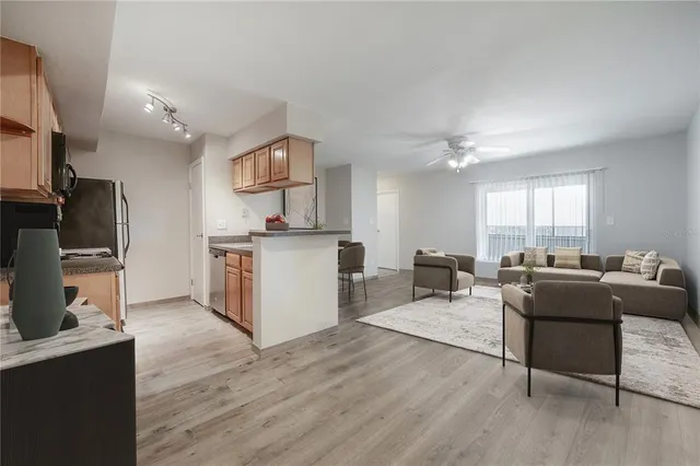 a living room with furniture a flat screen tv and kitchen view