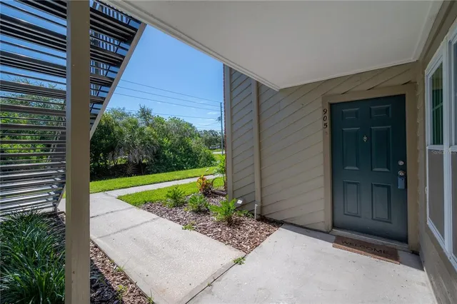 a living room with furniture a chandelier and a floor to ceiling window