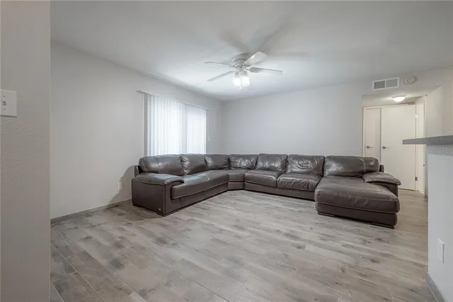 a living room with furniture and a ceiling fan