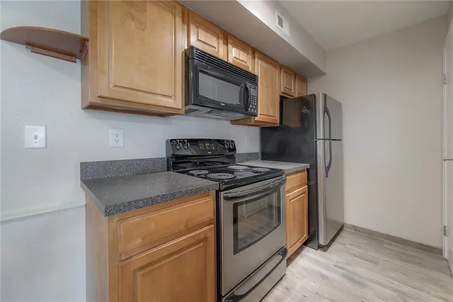 a kitchen with stainless steel appliances granite countertop a stove microwave and refrigerator